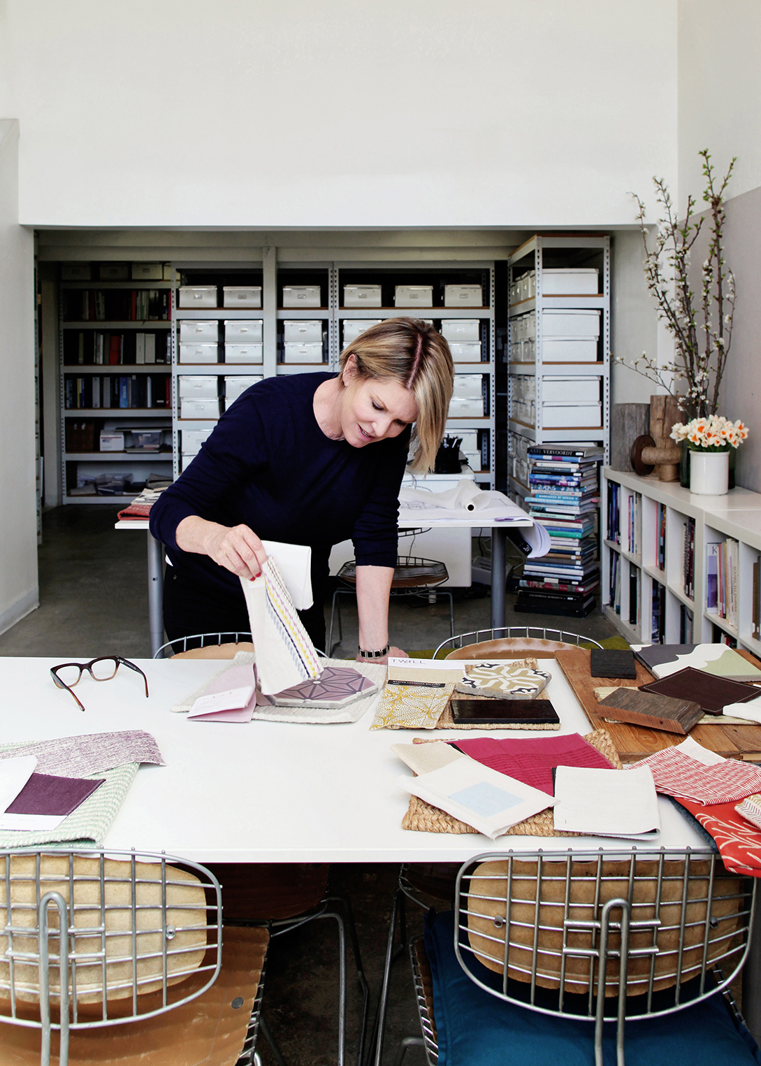 Inspiring environmental portrait by Kimberly Genevieve: Interior designer immersed in swatch selection process